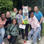 CMS Art Club poses with cat statue they painted