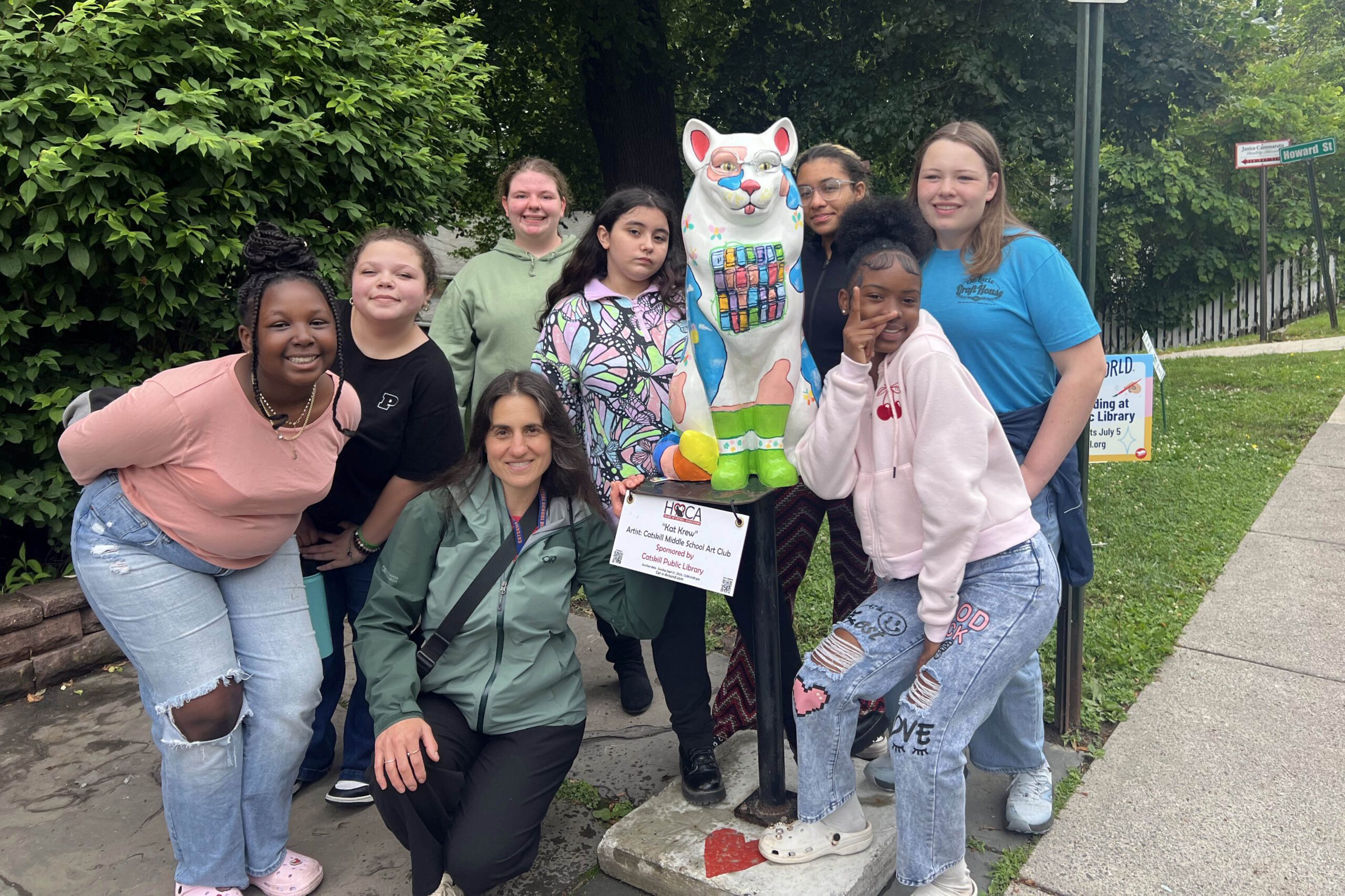 CMS Art Club poses with cat statue they painted