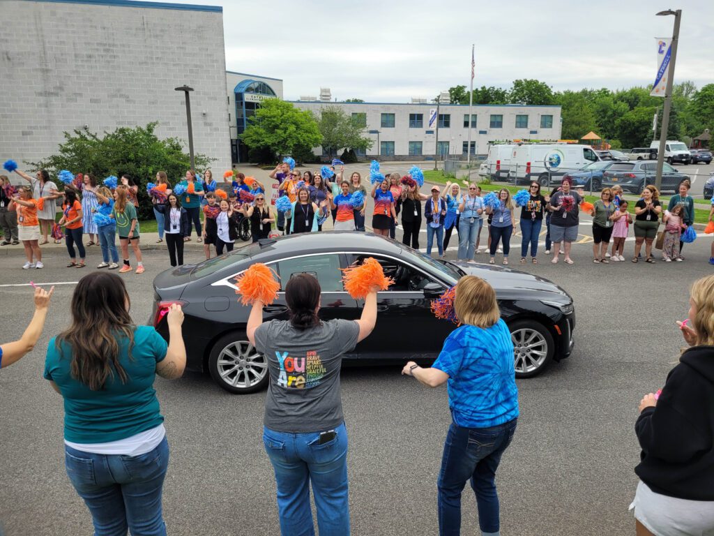 staff waving to car