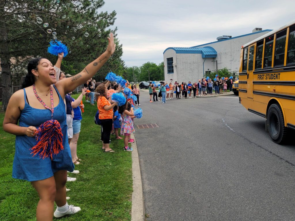 staff waving to buses