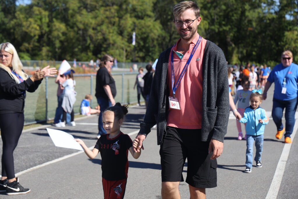 teacher and boy walking in parade