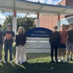 Six high school students posing by Catskill High School sign