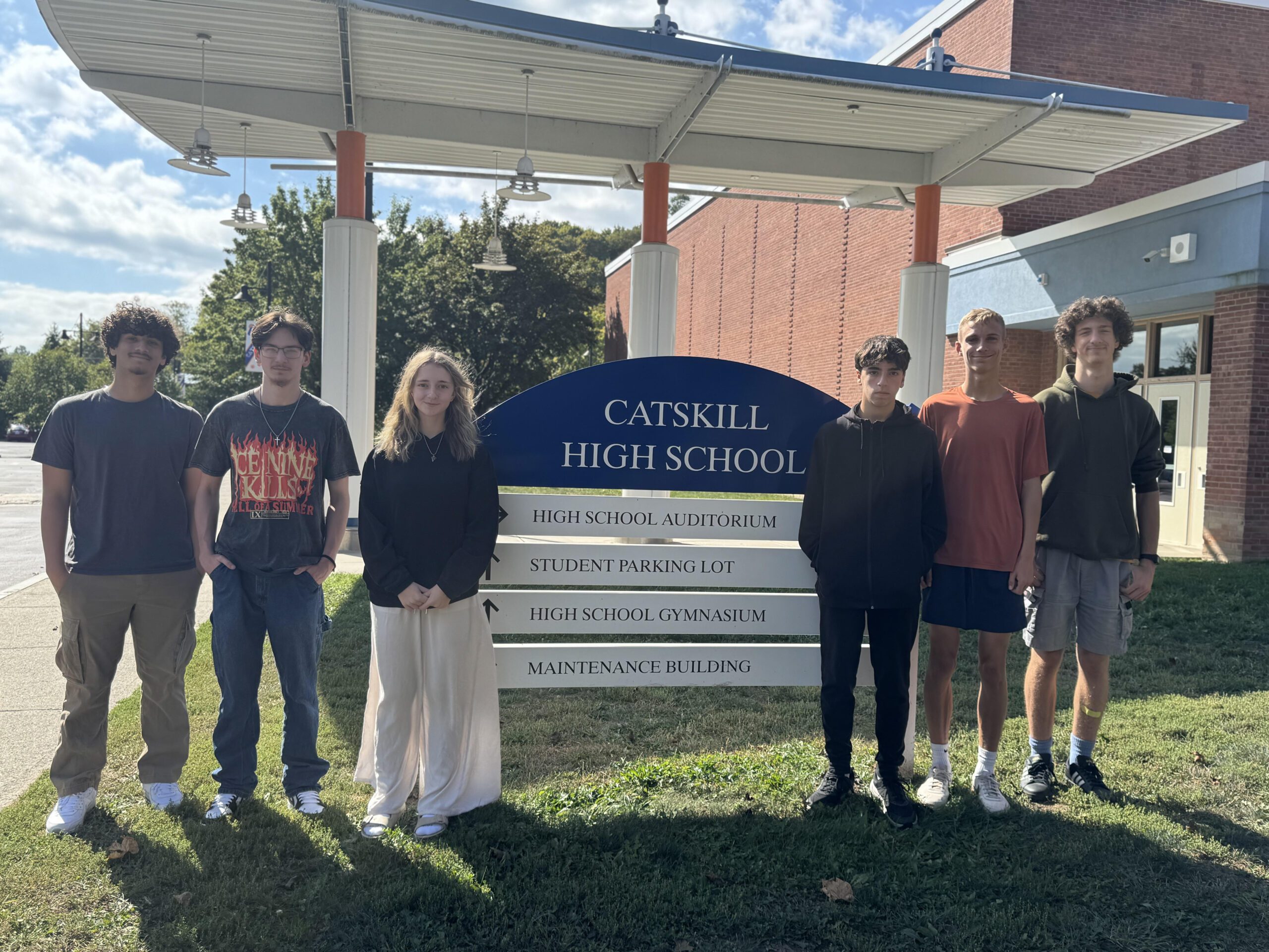 Six high school students posing by Catskill High School sign