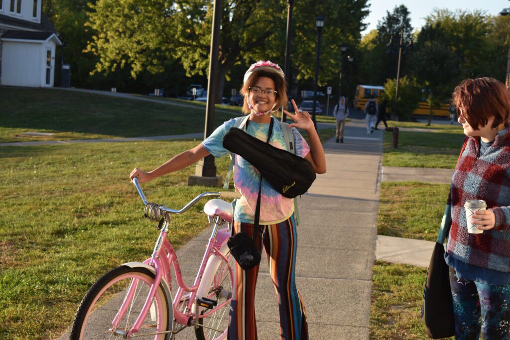 student dressed in seventies style clothing with retro bike