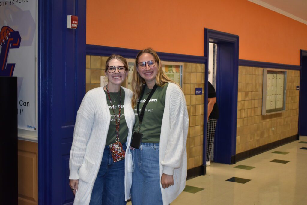two women wearing white sweaters