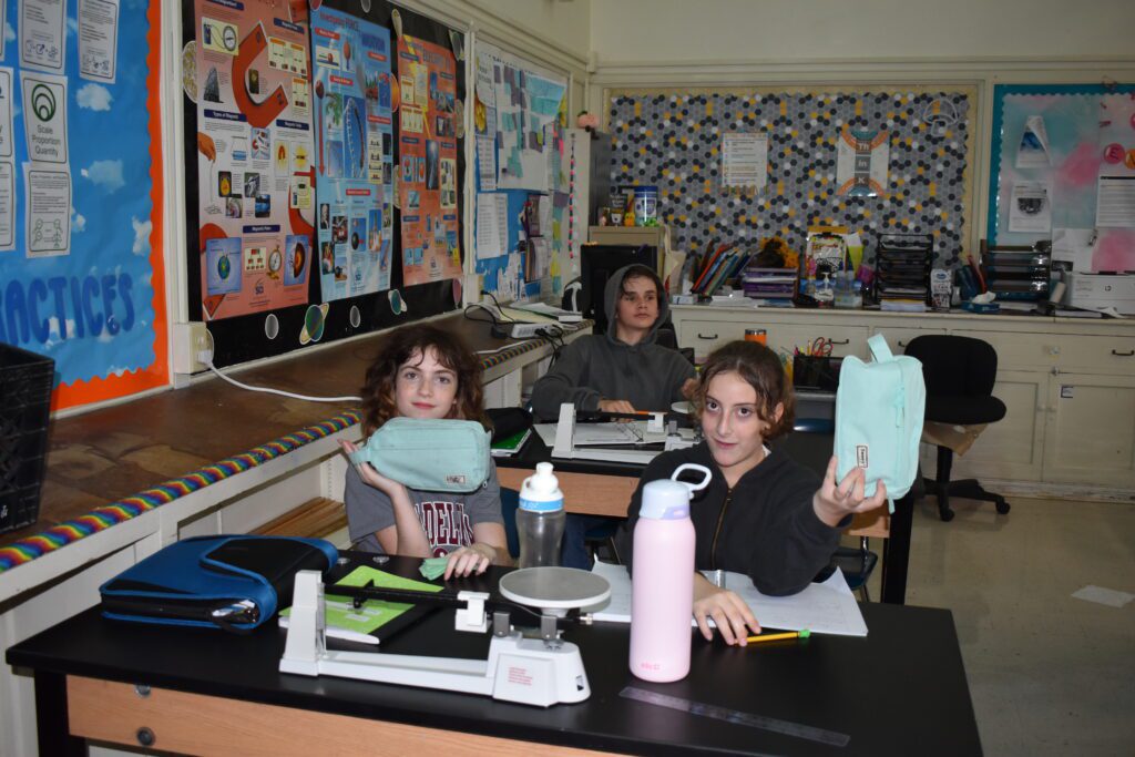 two girls holding up he same bag