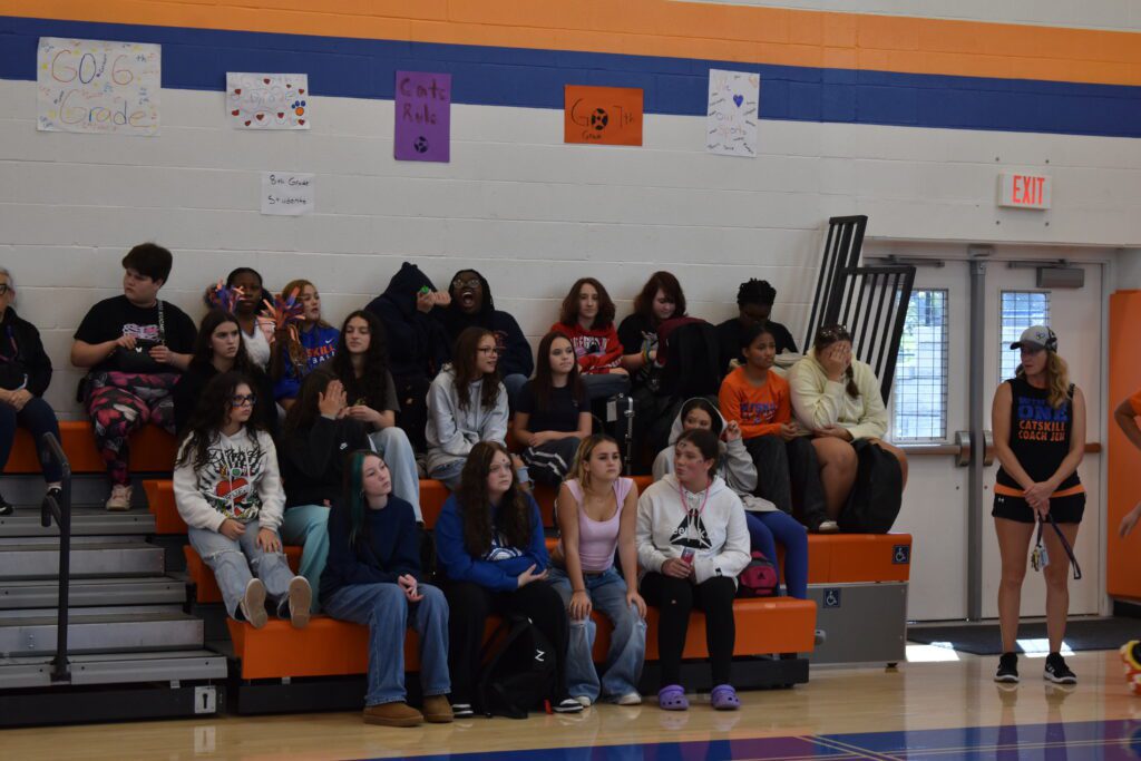 students sitting on bleachers in gym