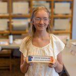teenage girl holding board member placard
