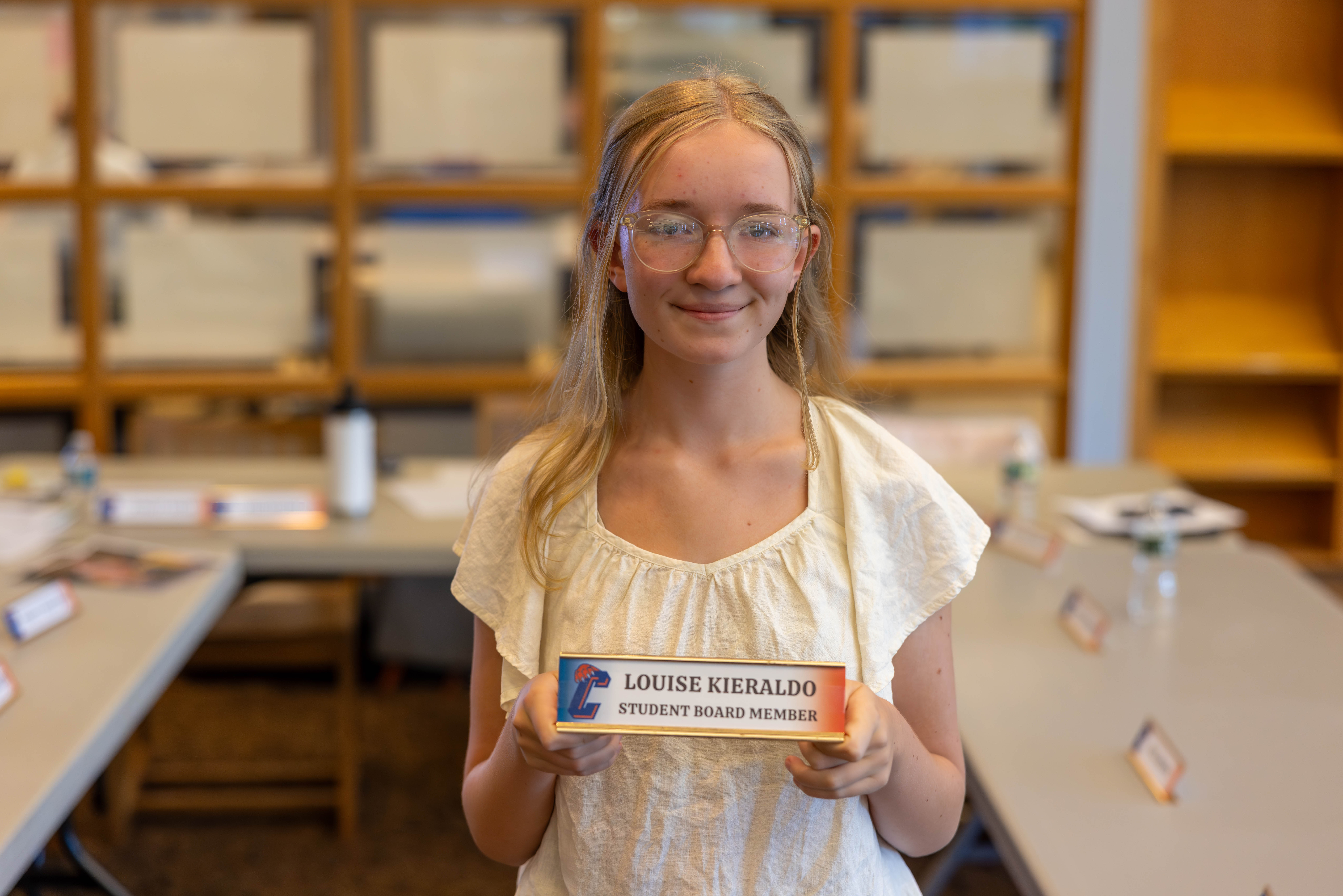 teenage girl holding board member placard