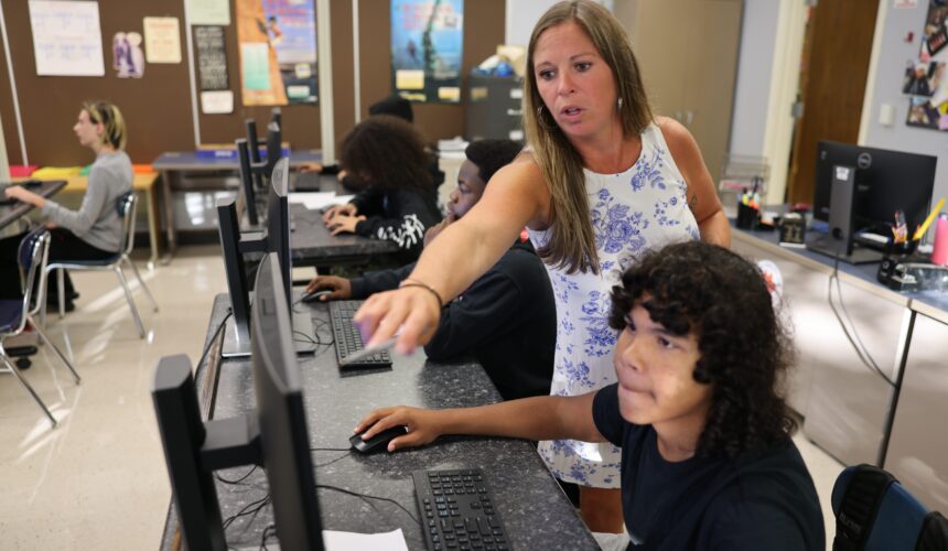 5Y4A9595 teacher points to computer screen while stunted sits at keypad