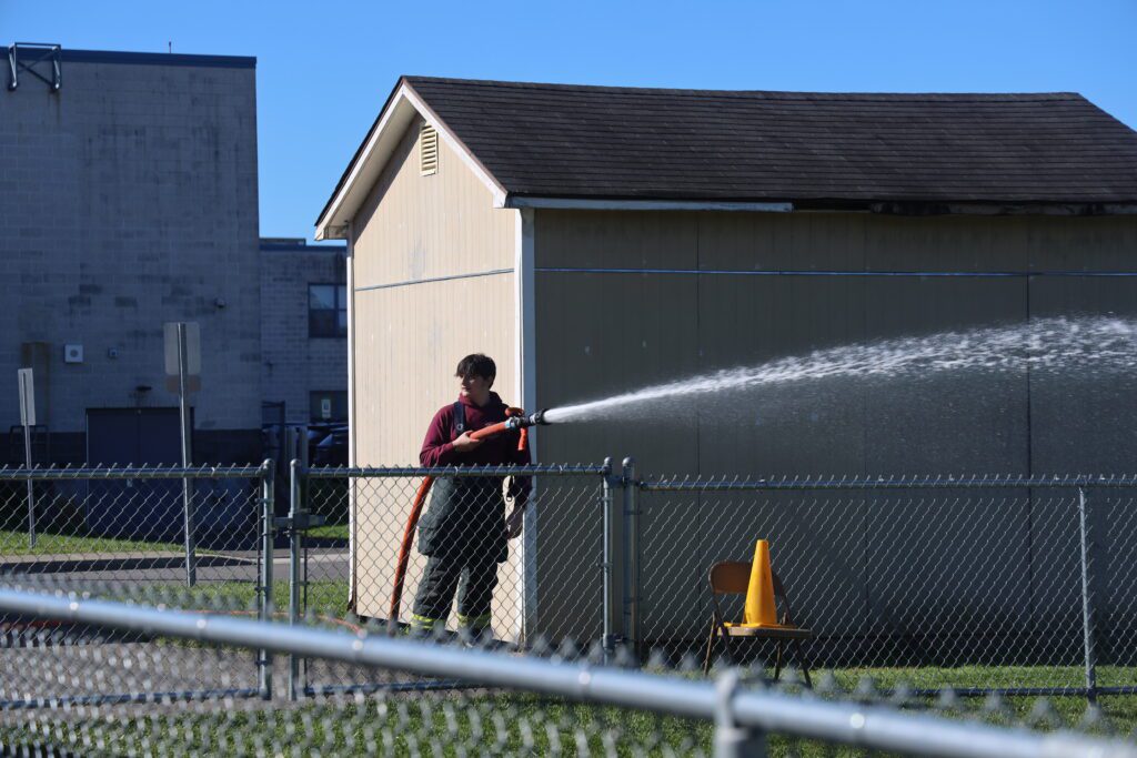 fireman spraying water with hose