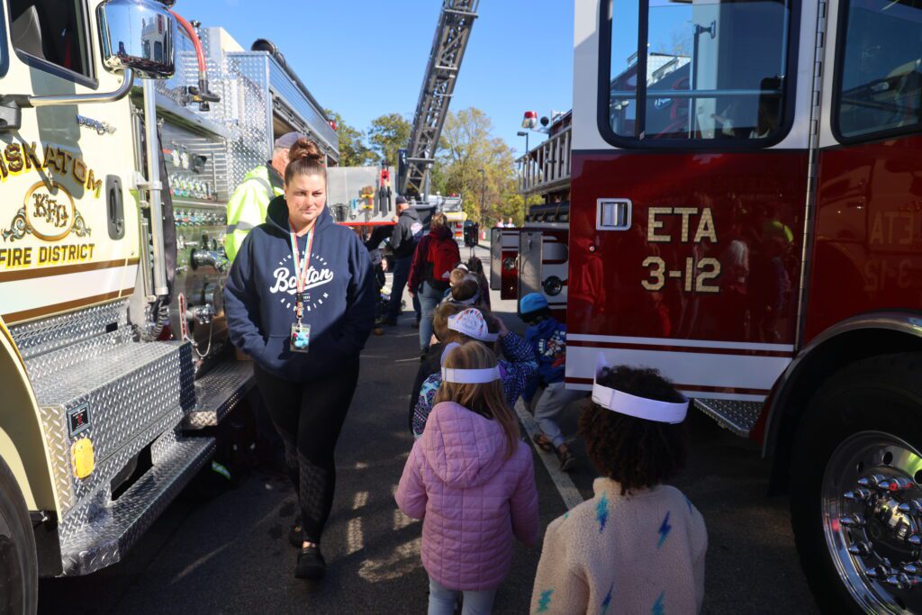 students walking alongside firetrucks