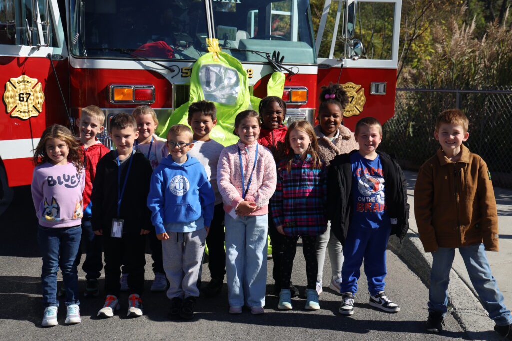 student pose with firetruck