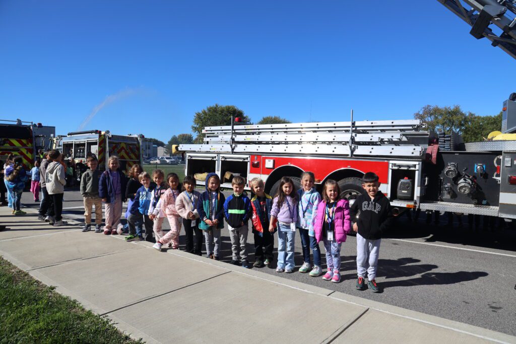 students pose with firetruck