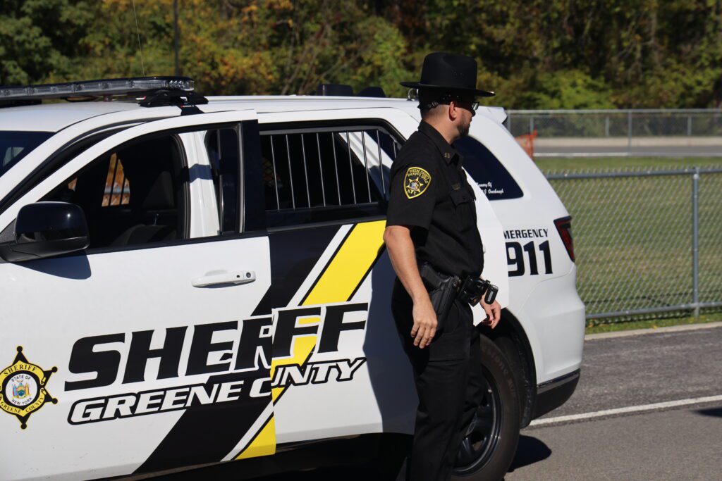 sheriff's deputy standing by police car