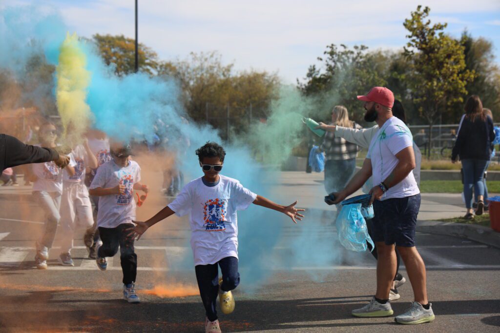 students running through clouds of colored dust