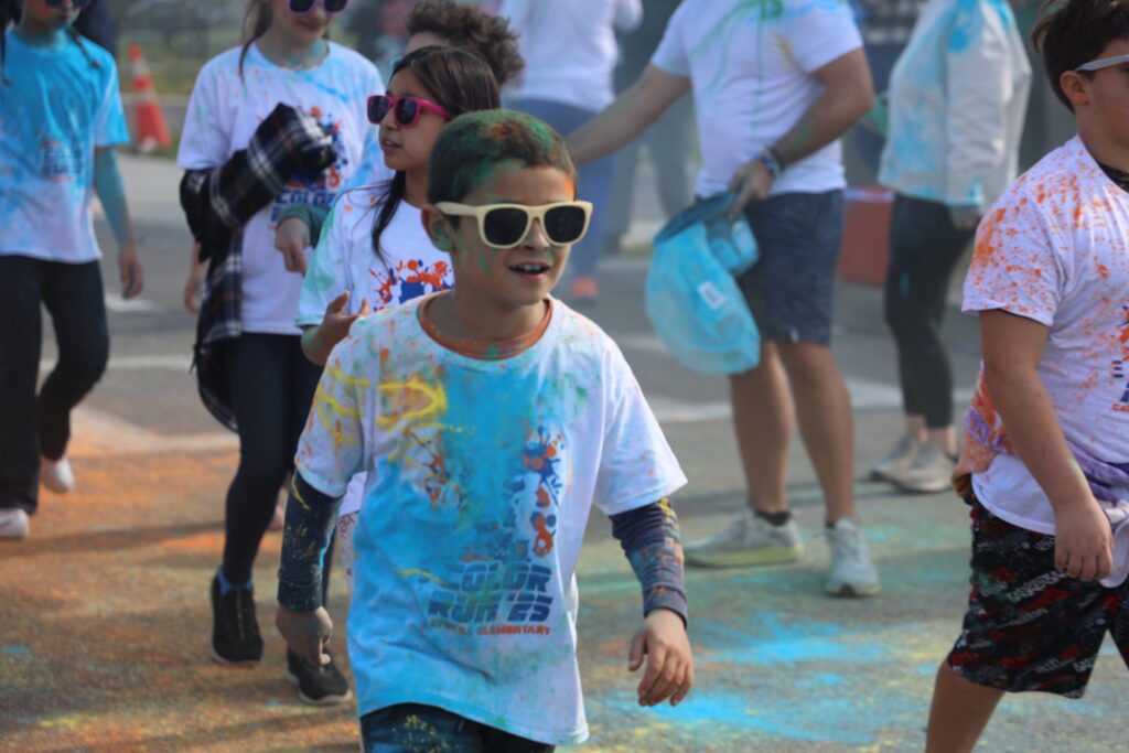 students running through clouds of colored dust