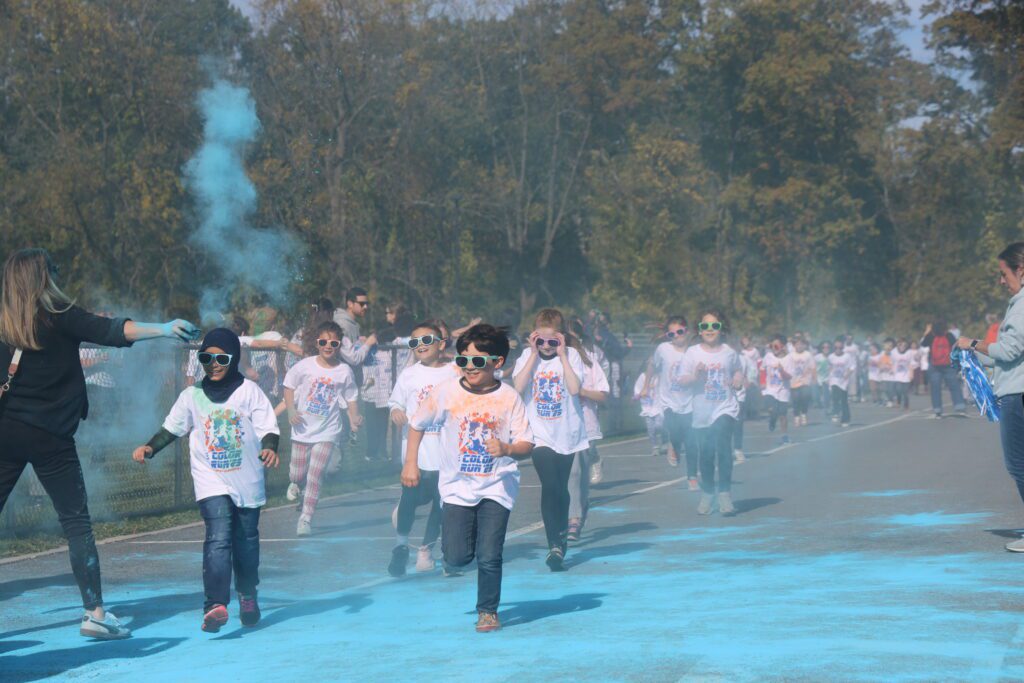students running through clouds of colored dust