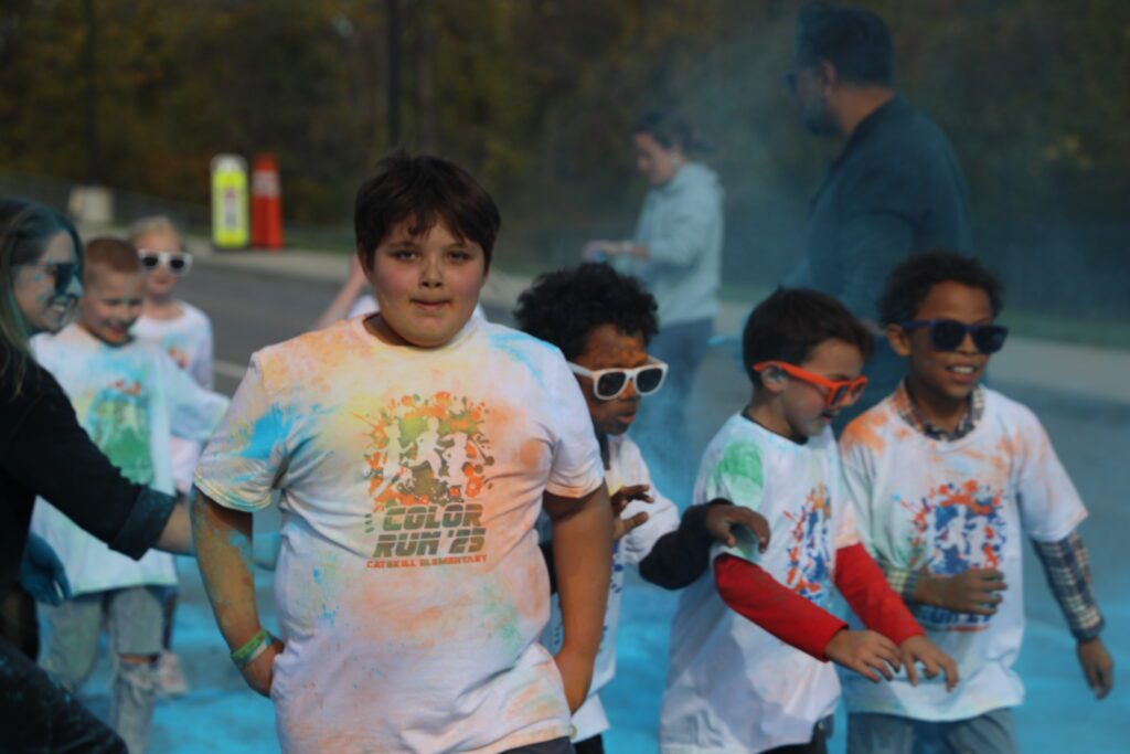 students running through clouds of colored dust