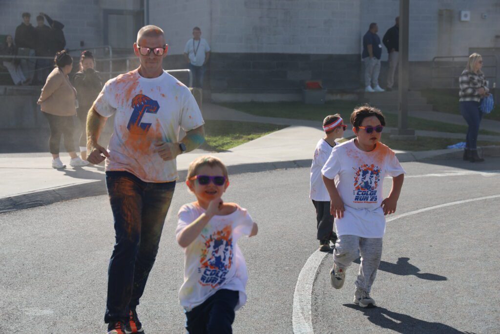 man and two boys running