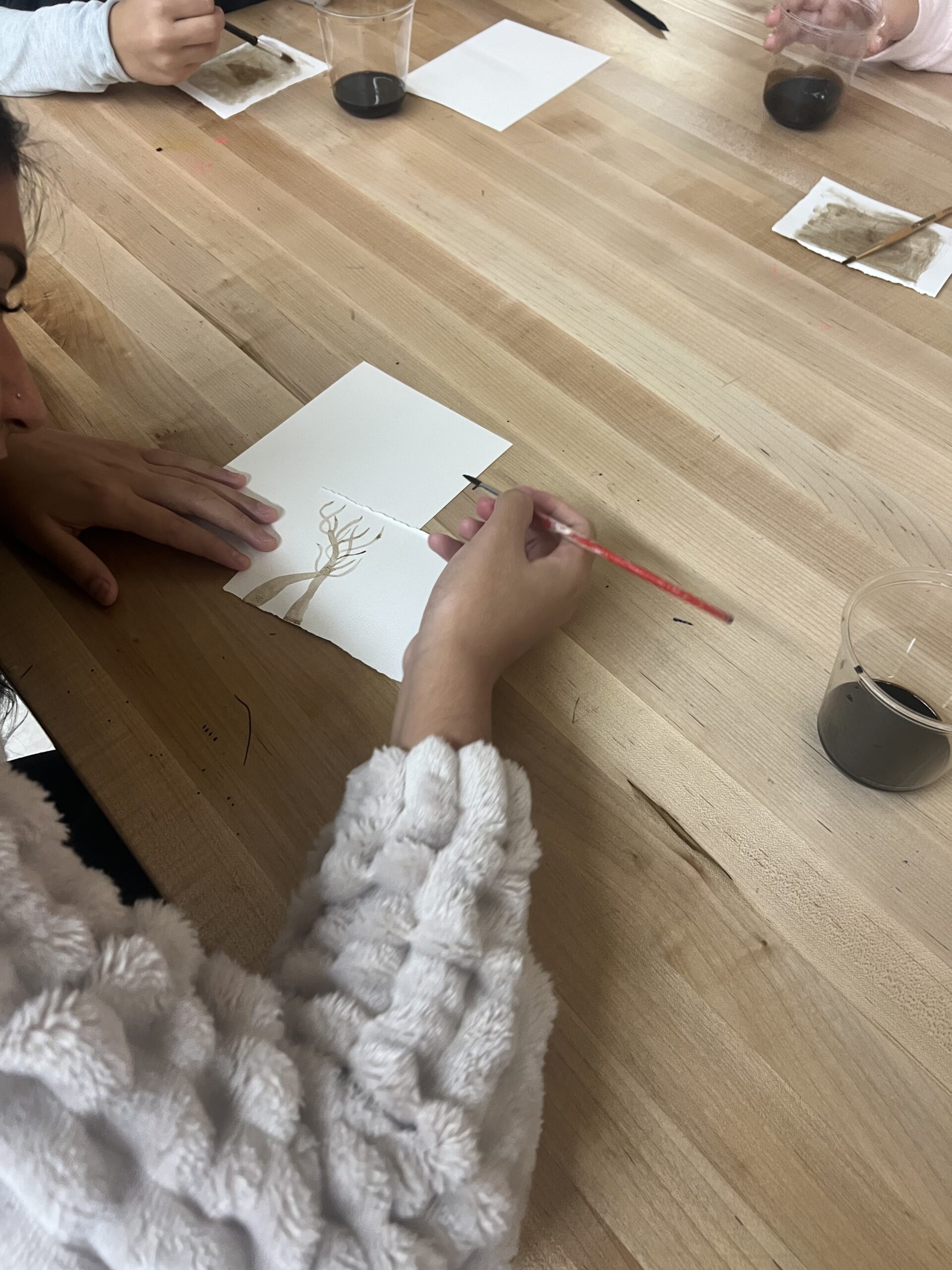 girl painting tree on paper