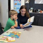 girl reading to young boy