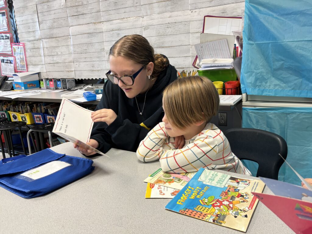 girl reading to young boy