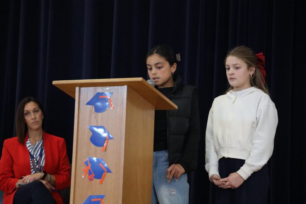 students speaking at podium