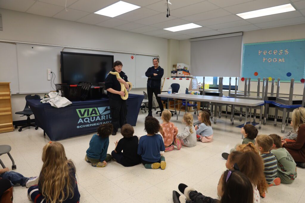 woman showing snake to young students
