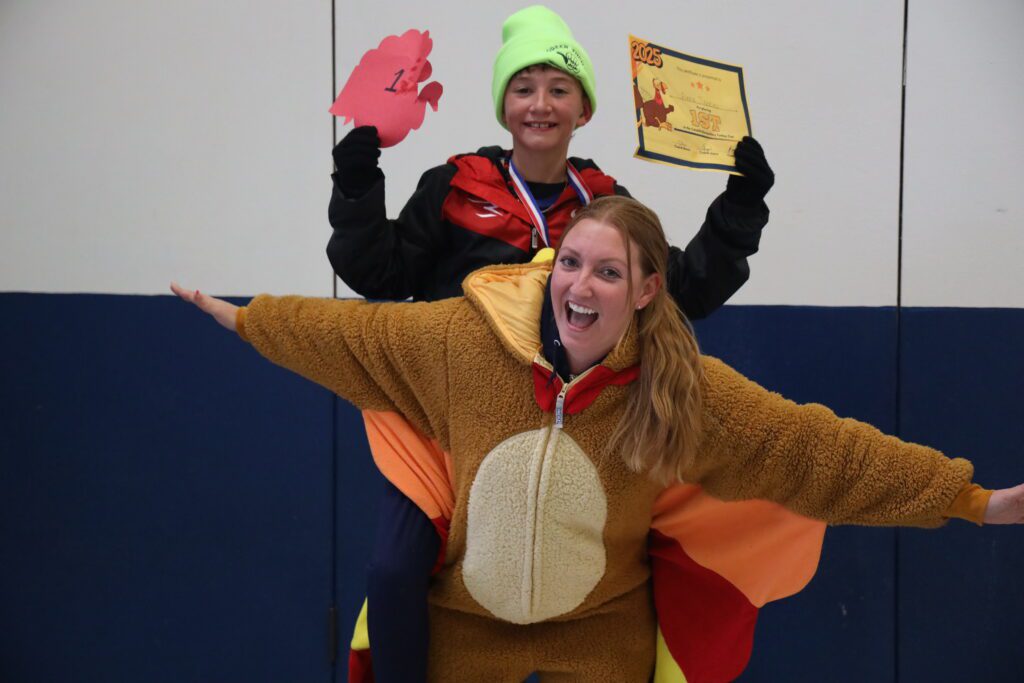 woman in turkey costume and young boy cheering