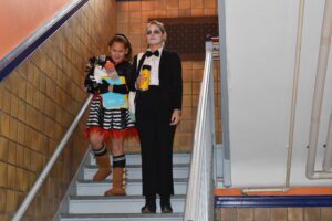 student and teacher in costumes descending stairs