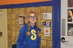 girl wear blue sweatshirt with S on it and glasses