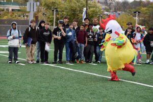 person in blow-up chicken costume running