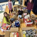 students pose with boxes filled with groceries