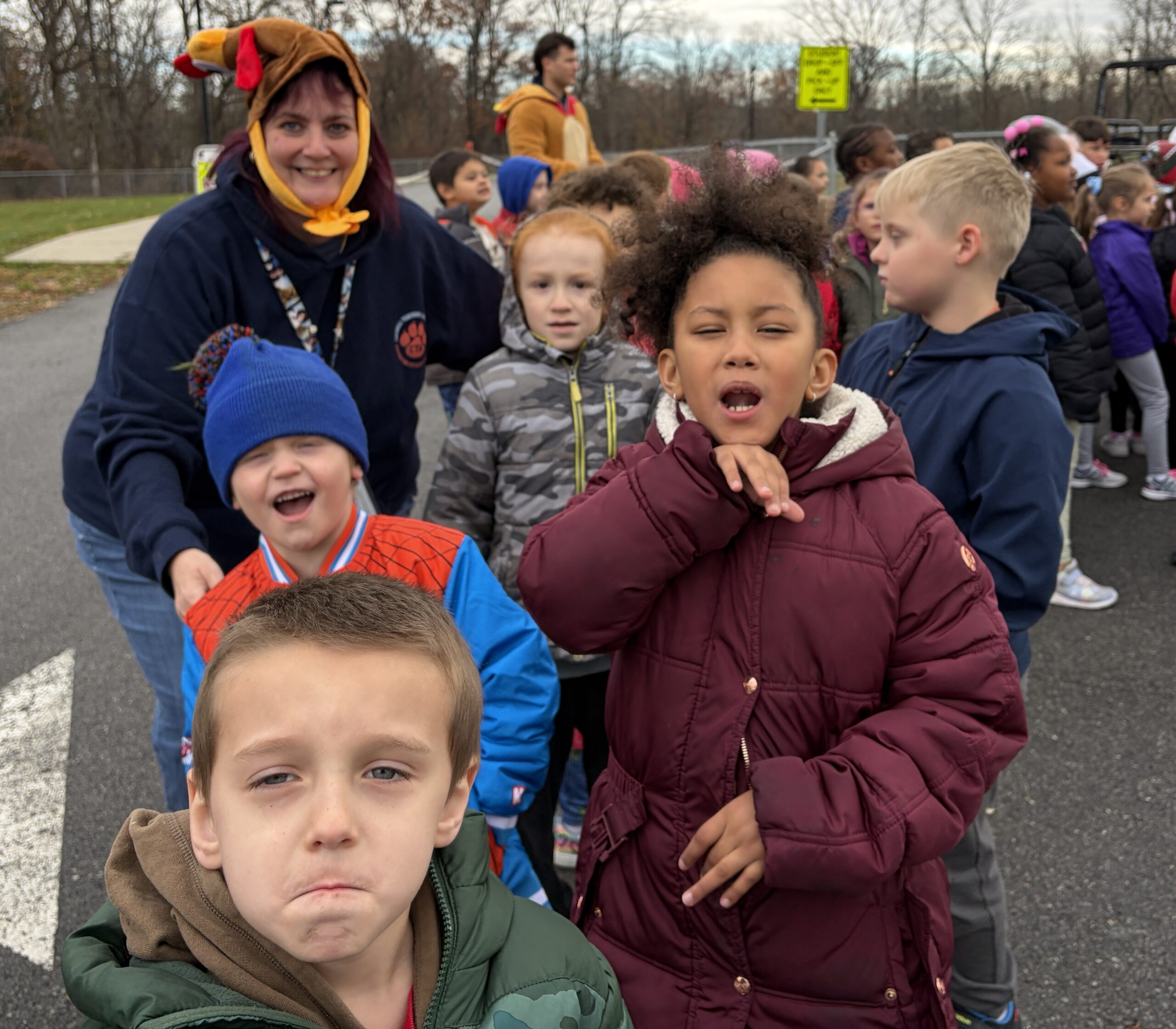 woman wearing turkey hat standing with group of students.