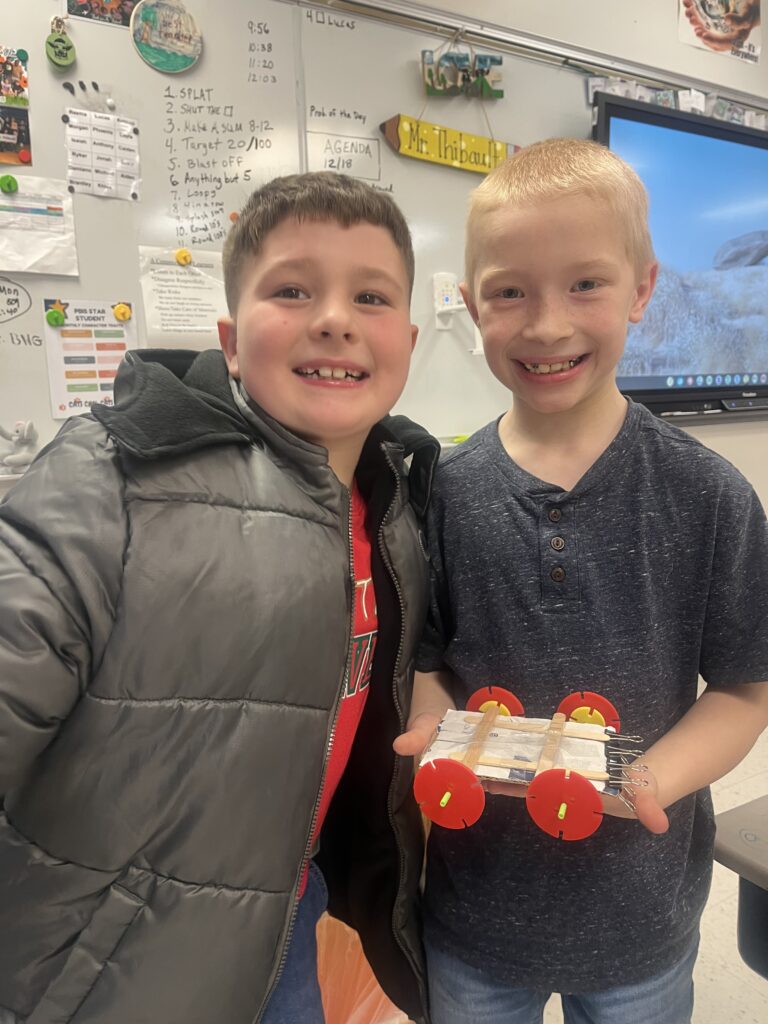 two boys posing with miniature wheeled cart