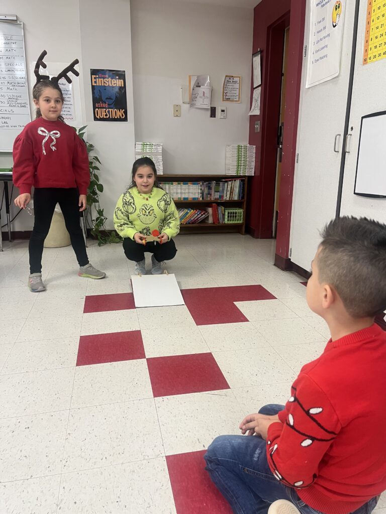 students testing miniature wheeled cart on floor