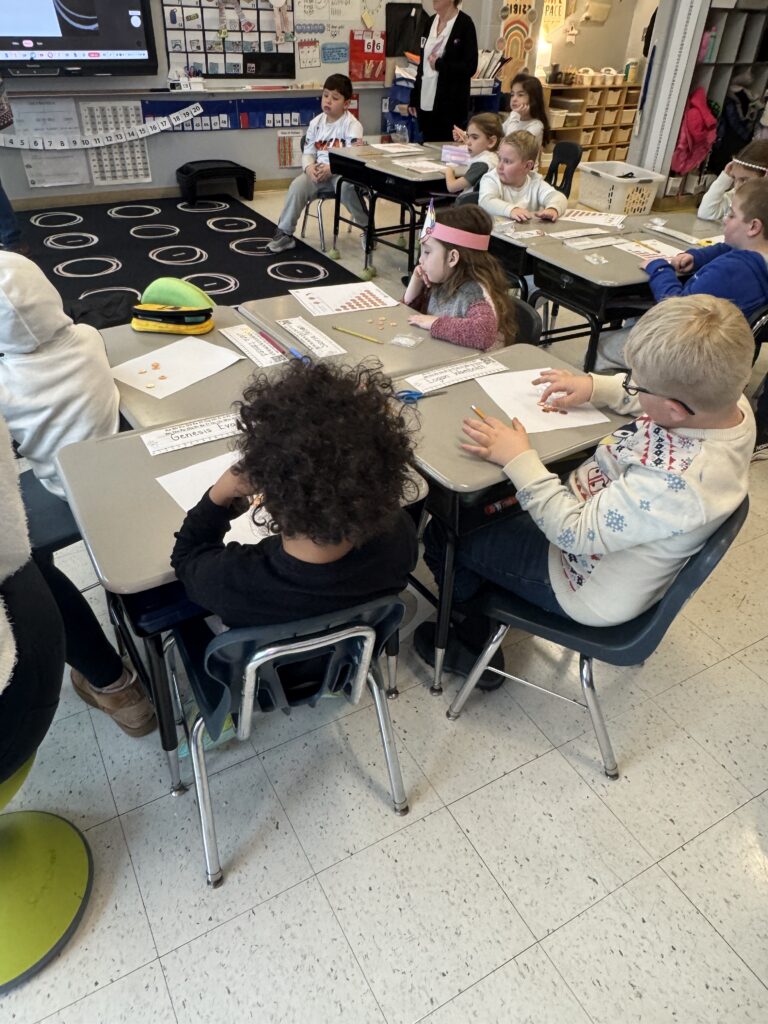 students sitting at desk counting coins