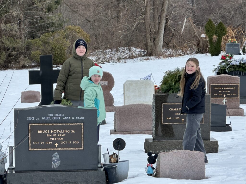 students laying wreaths on veterans' graves