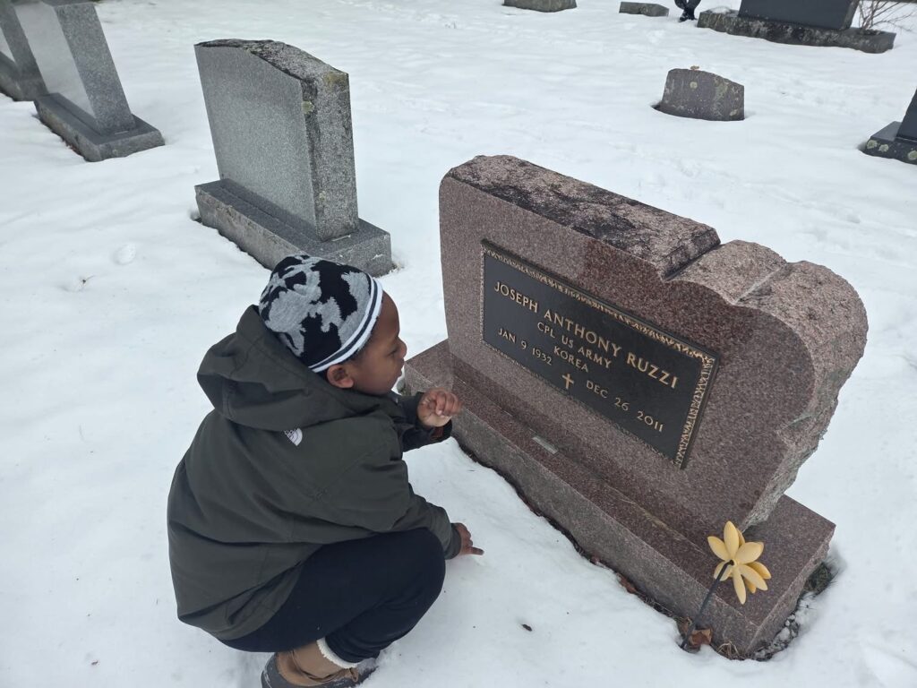 boy kneeling by tombstone