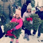 students laying wreaths on veterans' graves