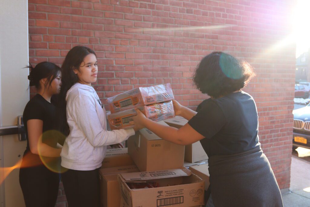teenage girls unloading boxes from pallet