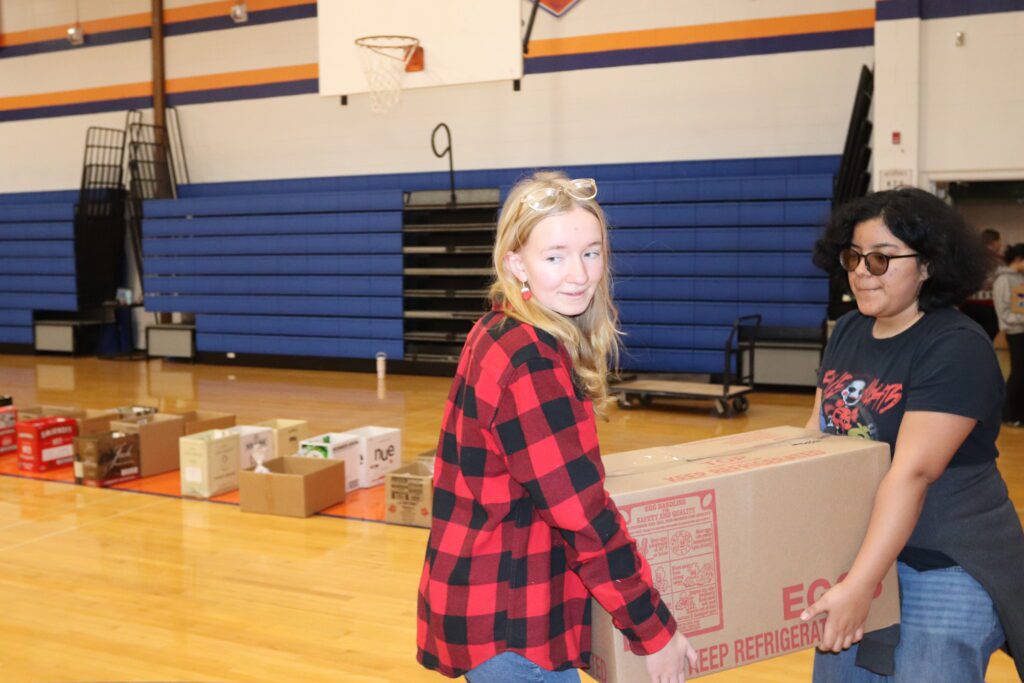 teenage girls carrying box