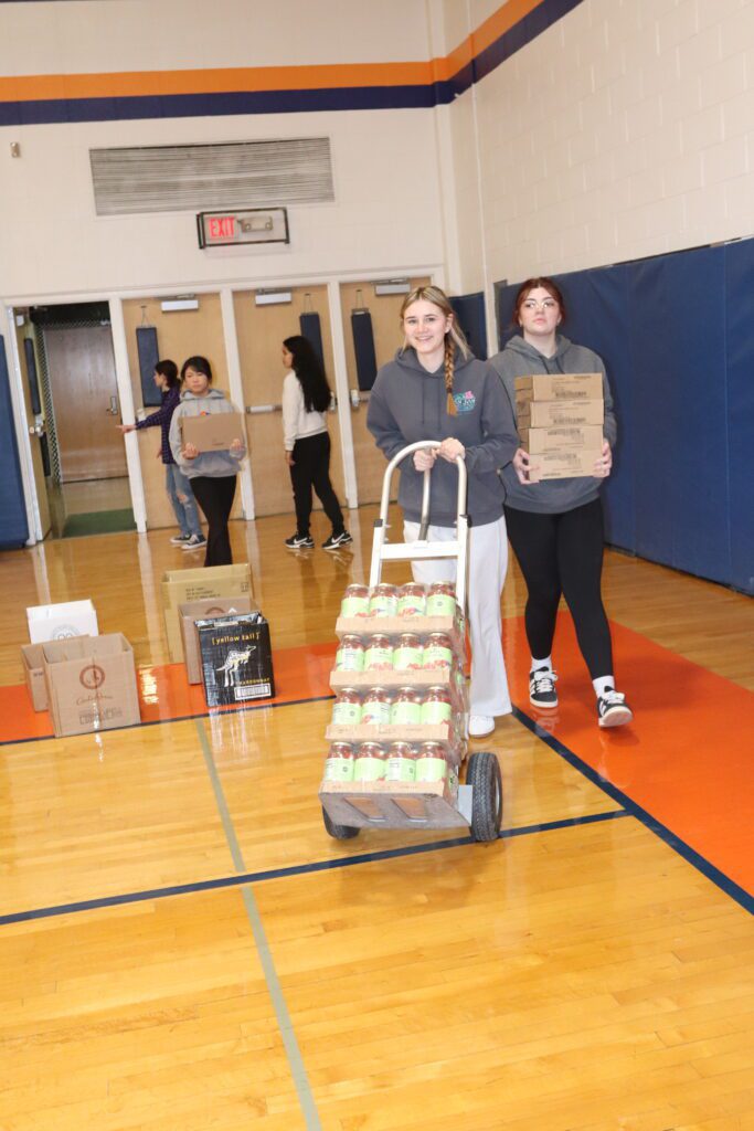teenage girls carrying boxes