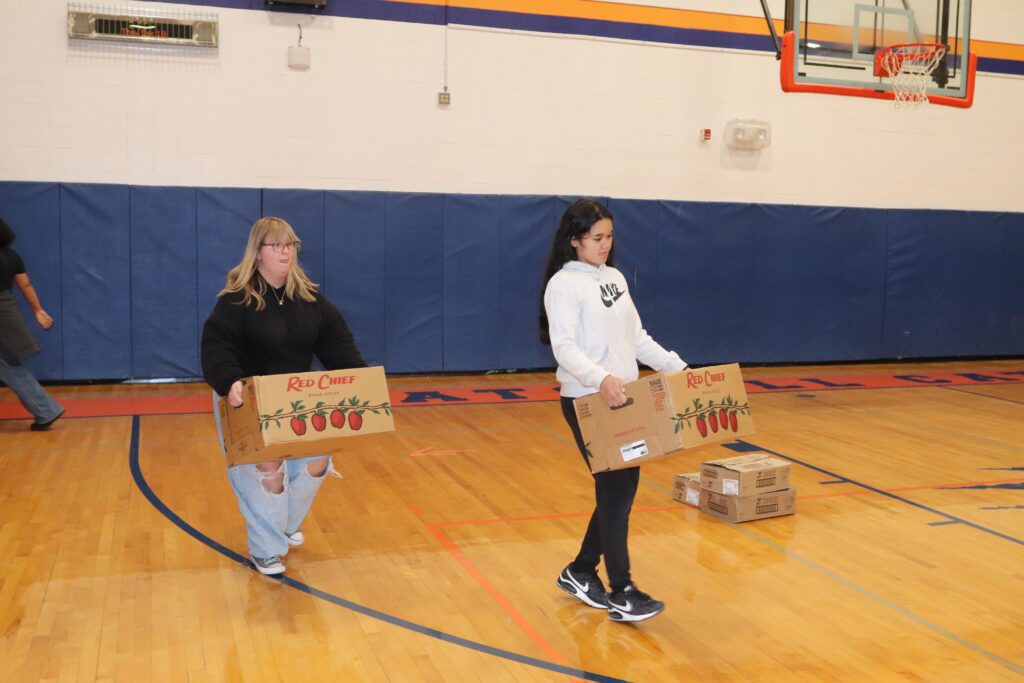 teenage girls carrying boxes
