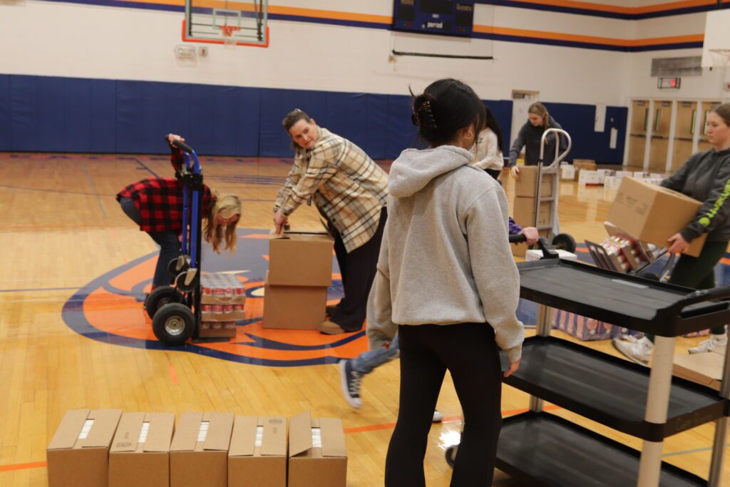 teenage girls and woman loading boxes