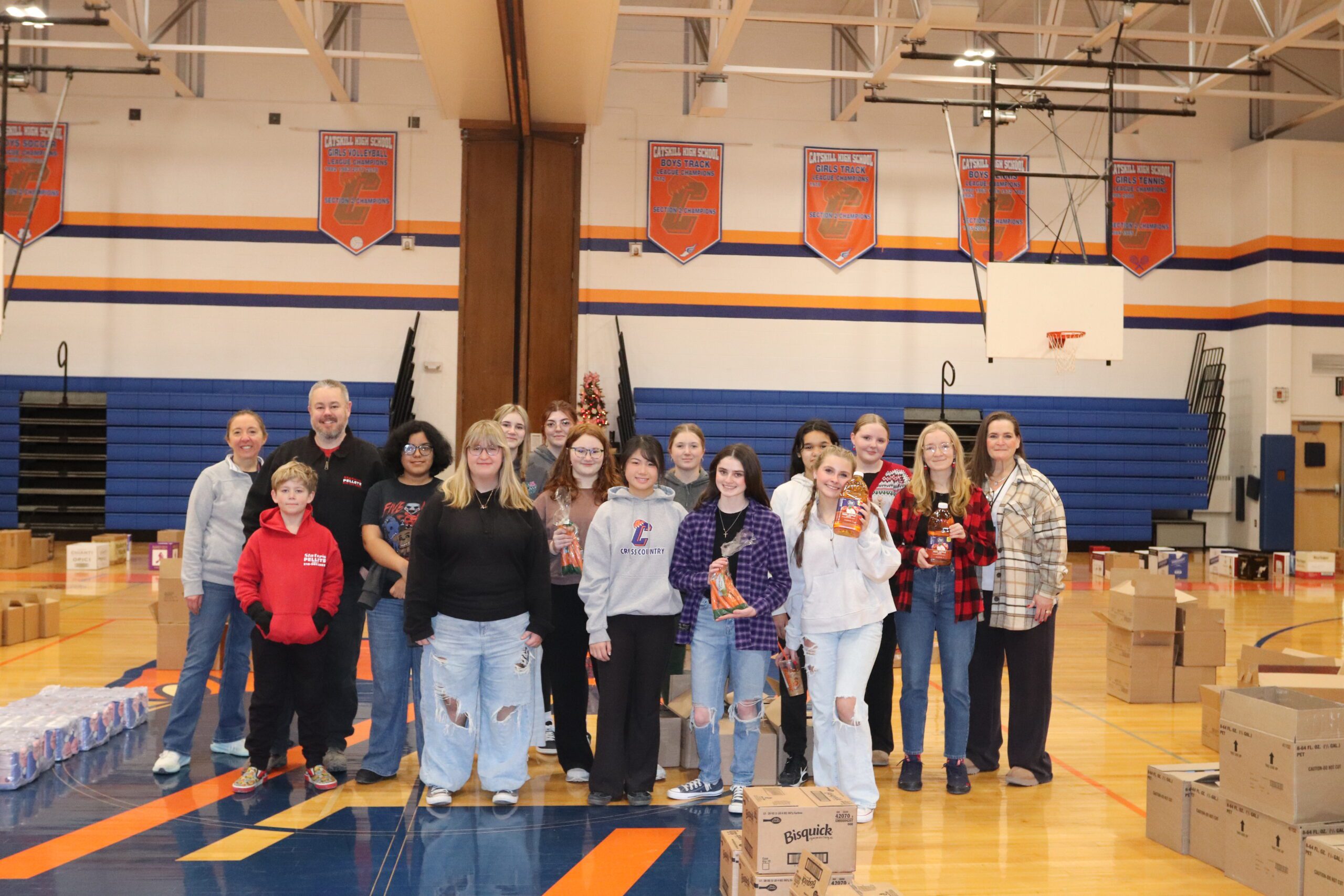 group photo of student in gym posing with food items