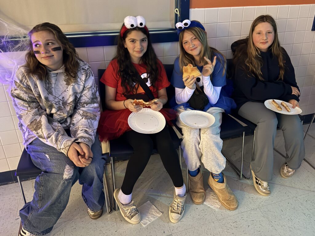 girls sitting at bench eating pizza