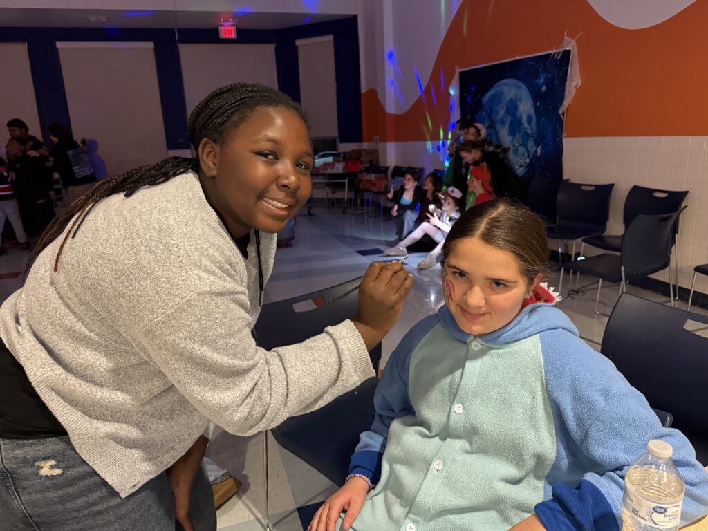 teenage girl painting middle school age girl's face