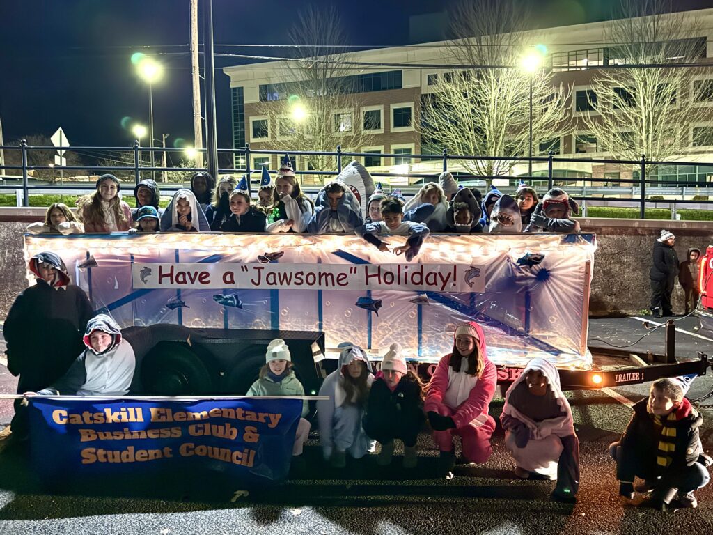 parade float with students dressed as sharks on it